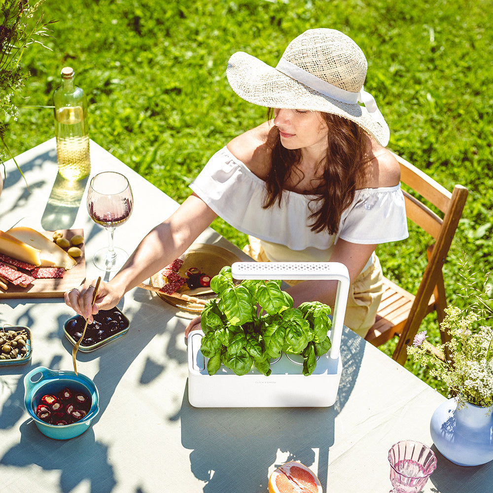 Click & grow Smart Garden 3 Indoor Kräutergarten Szene Frau Gartentisch